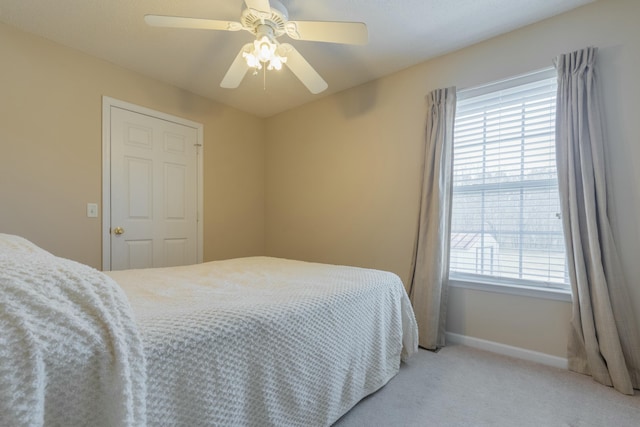 carpeted bedroom with multiple windows and ceiling fan