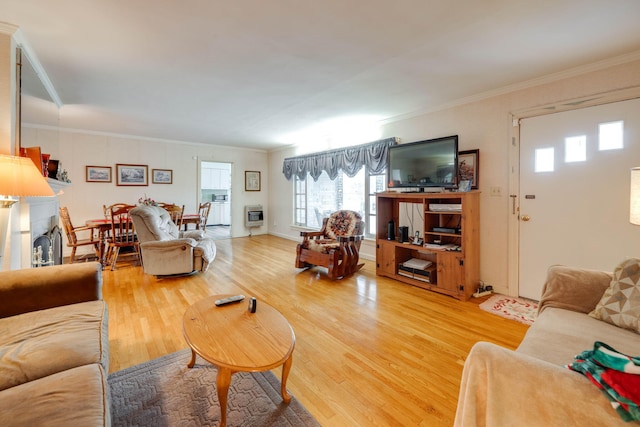 living room featuring heating unit, ornamental molding, and hardwood / wood-style flooring