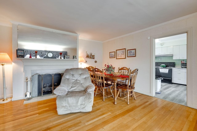 dining space featuring crown molding and light hardwood / wood-style flooring