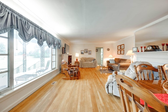 living room with light hardwood / wood-style floors and ornamental molding