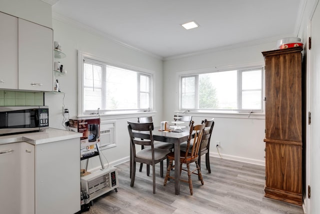 dining space featuring light wood-type flooring and crown molding