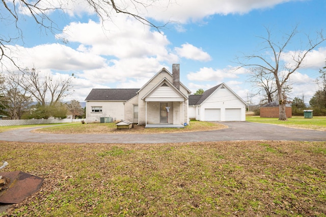 view of front of property featuring cooling unit, a front yard, and a garage