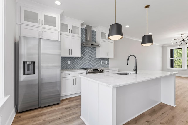 kitchen featuring white cabinets, appliances with stainless steel finishes, wall chimney exhaust hood, and sink