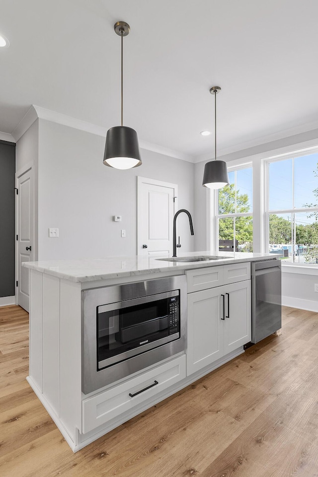 kitchen featuring sink, white cabinets, hanging light fixtures, and appliances with stainless steel finishes