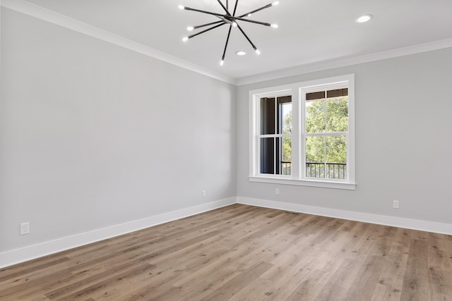 unfurnished room with light hardwood / wood-style floors, ornamental molding, and a notable chandelier