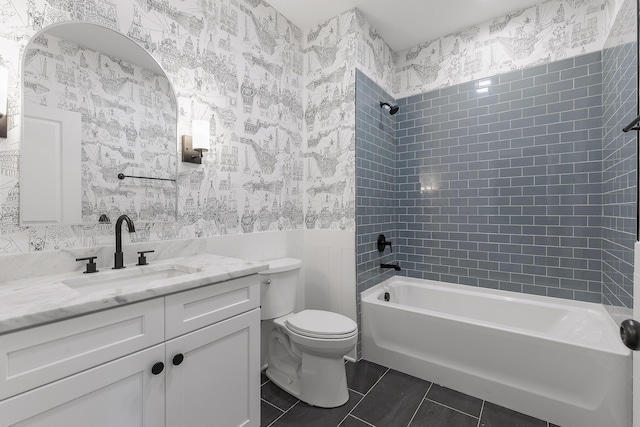 full bathroom with tile patterned floors, tiled shower / bath combo, toilet, and vanity