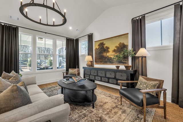 living room with wood-type flooring, vaulted ceiling, and an inviting chandelier