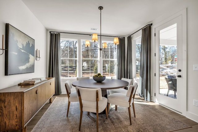 dining room featuring hardwood / wood-style floors and an inviting chandelier