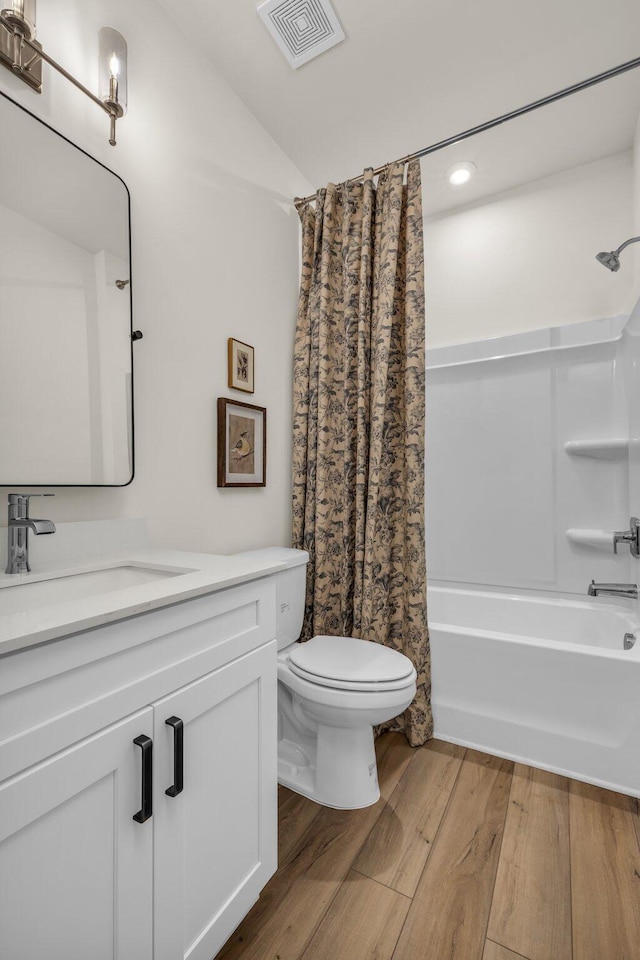 full bathroom with shower / tub combo, vanity, wood-type flooring, toilet, and lofted ceiling