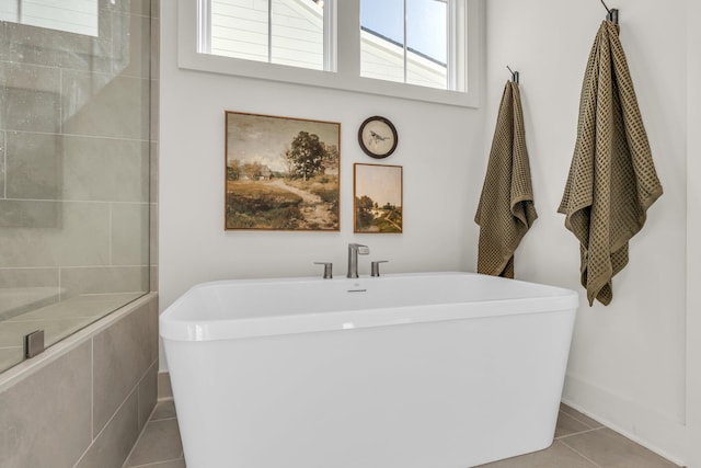 bathroom with a bath and tile patterned floors