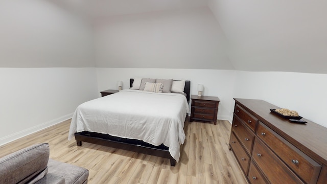 bedroom featuring light wood-type flooring and lofted ceiling