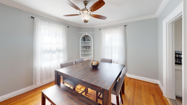 dining room with ceiling fan, ornamental molding, and light wood-type flooring