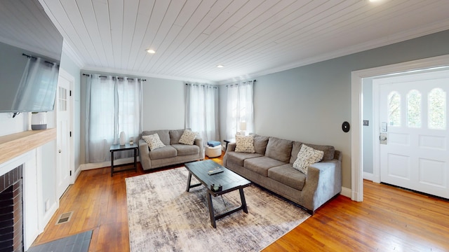 living room with crown molding, a fireplace, wood ceiling, and wood-type flooring