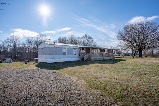 manufactured / mobile home with covered porch and a front lawn