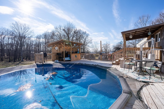 view of pool with exterior bar and a deck