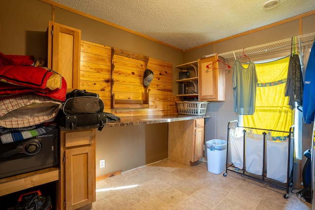 laundry area featuring a textured ceiling and ornamental molding