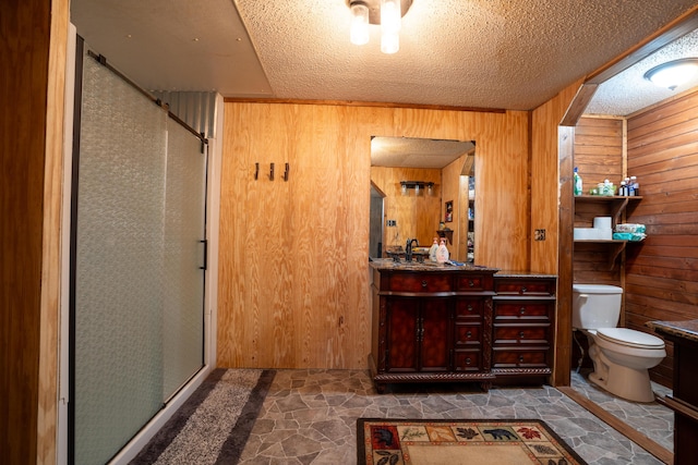 bathroom with vanity, toilet, walk in shower, and wooden walls