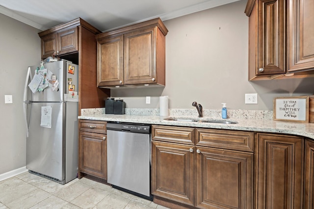 kitchen with light stone counters, stainless steel appliances, light tile patterned flooring, a sink, and baseboards