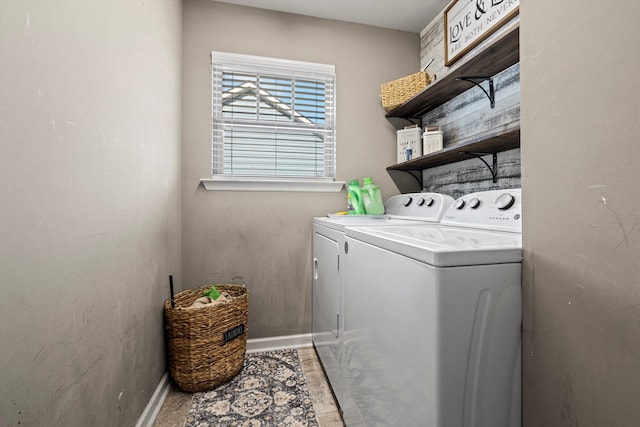 clothes washing area featuring laundry area, baseboards, and separate washer and dryer