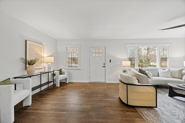 living room featuring ceiling fan and dark wood-type flooring