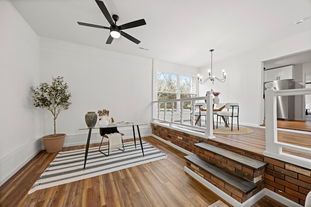 dining space featuring hardwood / wood-style floors and ceiling fan with notable chandelier