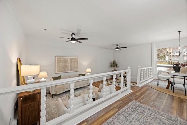 interior space featuring ceiling fan with notable chandelier and dark hardwood / wood-style floors