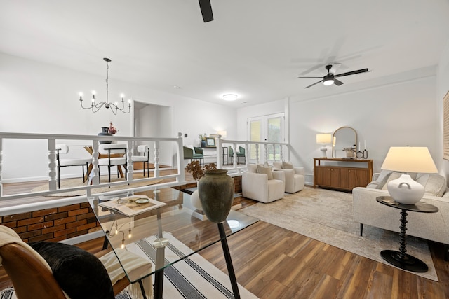 living room with light hardwood / wood-style flooring and ceiling fan with notable chandelier