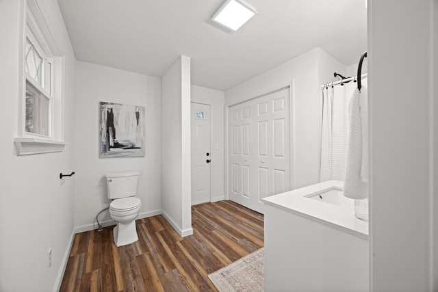 bathroom featuring toilet, vanity, and hardwood / wood-style flooring