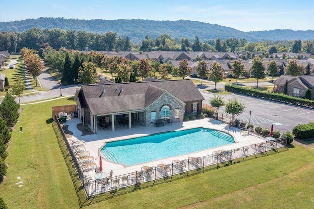 view of pool featuring a yard, a mountain view, and a patio area