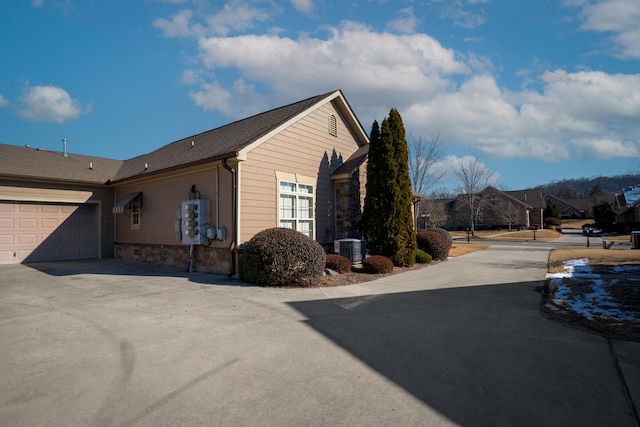 view of home's exterior with cooling unit and a garage