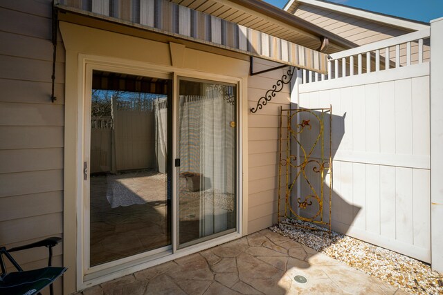 view of exterior entry with a patio