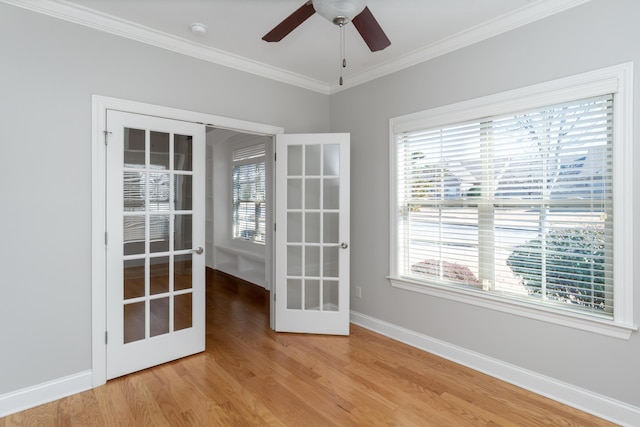 empty room with hardwood / wood-style flooring, ceiling fan, french doors, and crown molding