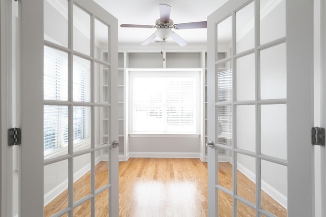 spacious closet with ceiling fan, french doors, and wood-type flooring