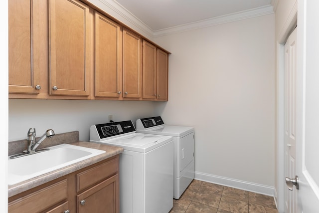 laundry area with tile patterned flooring, washing machine and dryer, cabinets, crown molding, and sink