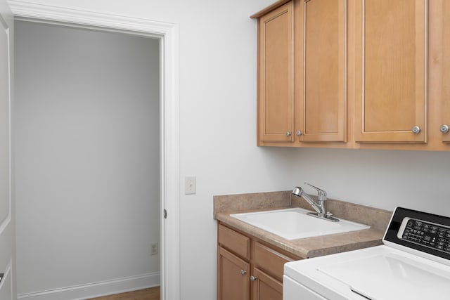 washroom with washer / dryer, cabinets, and sink