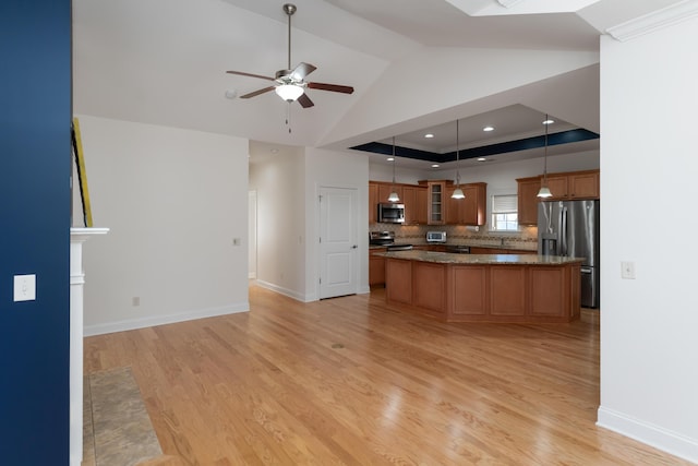 kitchen with pendant lighting, a center island, stainless steel appliances, backsplash, and ceiling fan