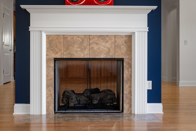 room details featuring a tiled fireplace and hardwood / wood-style floors