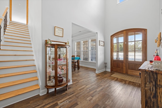 entrance foyer with crown molding, french doors, dark hardwood / wood-style flooring, and a high ceiling