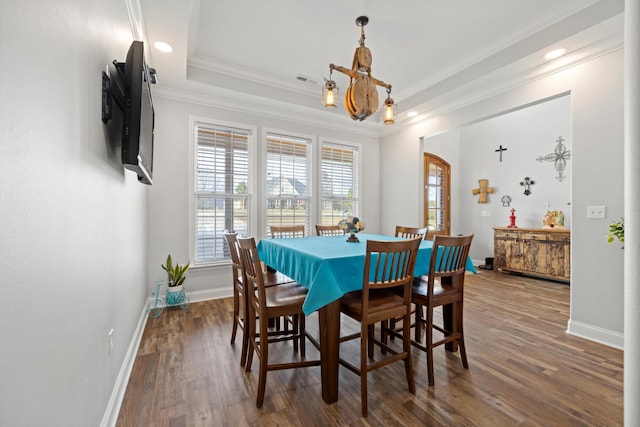 dining space featuring crown molding, dark hardwood / wood-style floors, and a tray ceiling