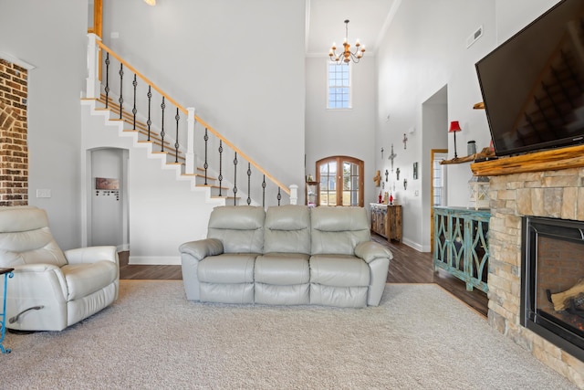 living room featuring a fireplace, a high ceiling, and a chandelier