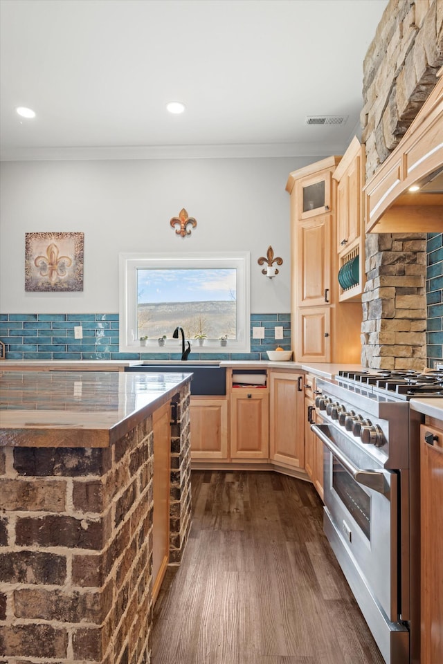 kitchen featuring backsplash, dark hardwood / wood-style floors, high end range, crown molding, and light brown cabinets