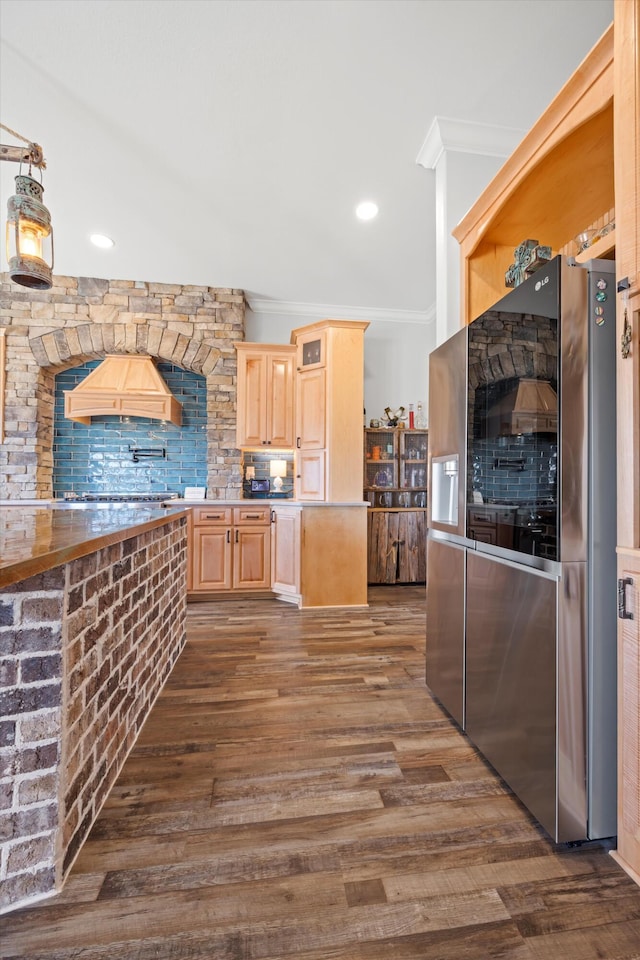 kitchen featuring stainless steel fridge with ice dispenser, tasteful backsplash, light brown cabinetry, custom range hood, and ornamental molding