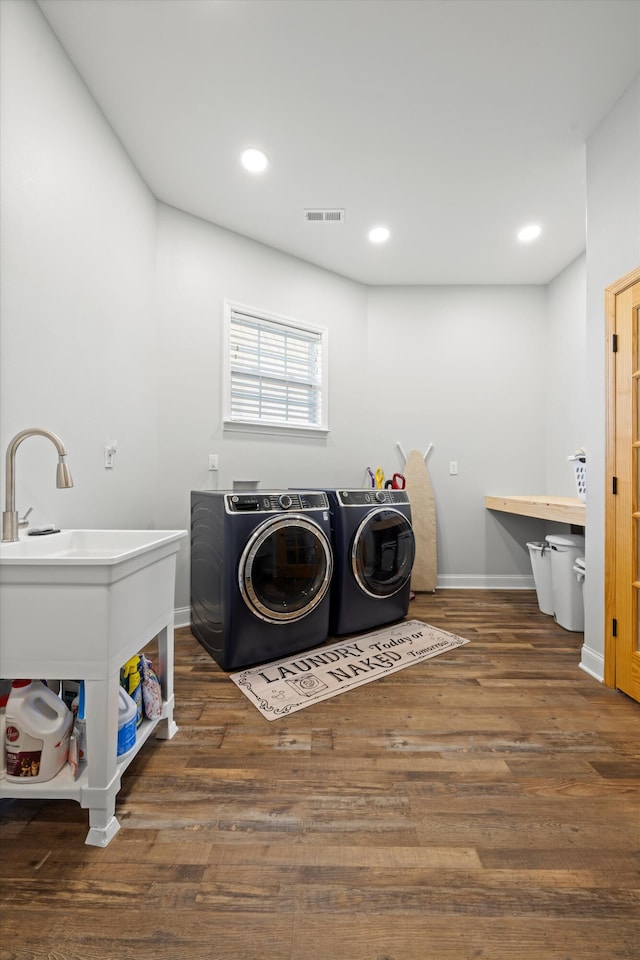 clothes washing area featuring dark hardwood / wood-style flooring and washer and dryer