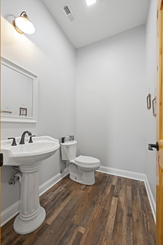 bathroom with toilet and hardwood / wood-style flooring