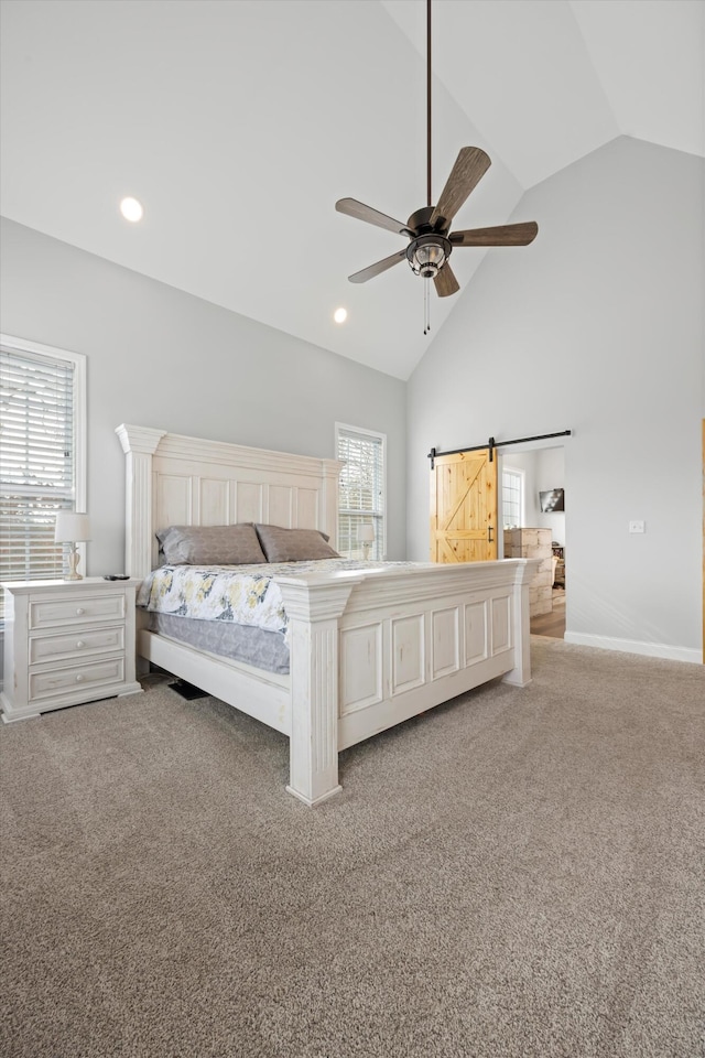 unfurnished bedroom featuring ceiling fan, light colored carpet, a barn door, and vaulted ceiling