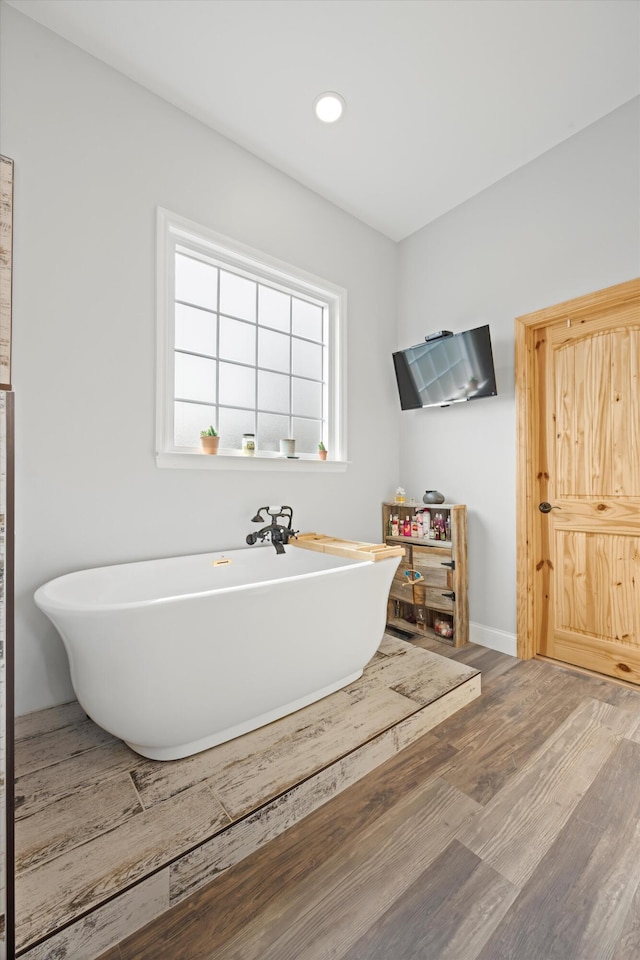 bathroom with hardwood / wood-style floors and a tub