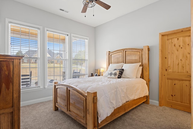 carpeted bedroom with ceiling fan and multiple windows