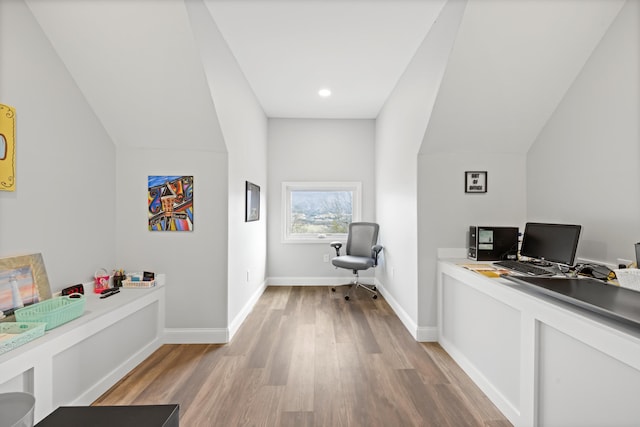 home office with light hardwood / wood-style floors and vaulted ceiling