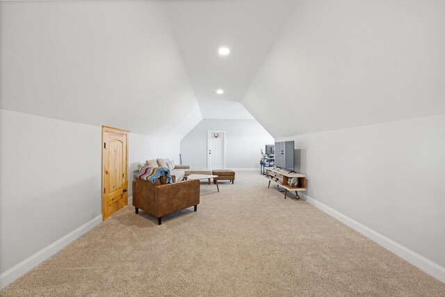 sitting room with vaulted ceiling and carpet flooring