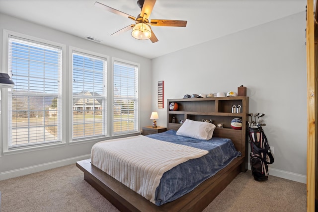 bedroom with ceiling fan and light carpet